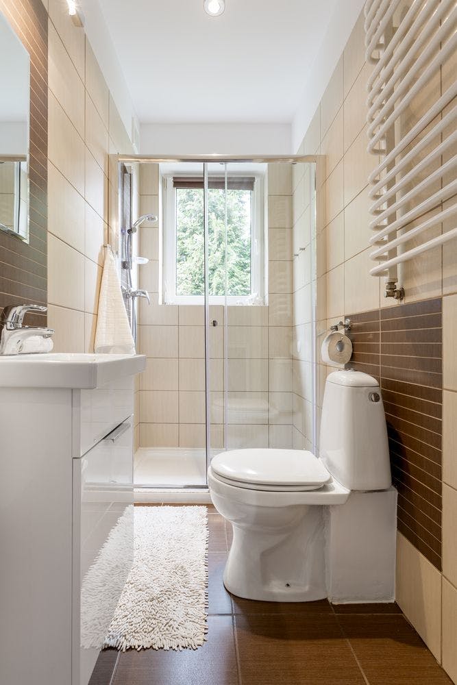 Remodeled bathroom with white tiles and new toilet